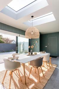 チチェスターにあるDownsea - coastal retreat in East Witteringの白いテーブルと椅子のあるダイニングルーム