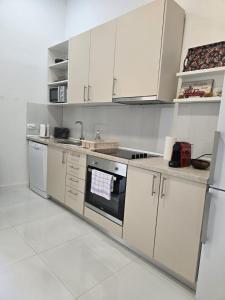 een keuken met witte kasten en een kookplaat oven bij Mostar in Mostar