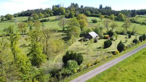 an aerial view of a field with a house and a road at Un Chalet en Corrèze in Auriac