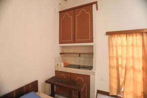 a small kitchen with brown cabinets and a table at Mango Tree Retreat in Bambawa +48 photos