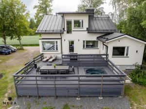 a large deck in front of a house at Villa Gaia! - Luxury villa with jacuzzi and beach close to trainstation 10 minutes from Tampere city! 1,5 hours to Helsinki in Tampere