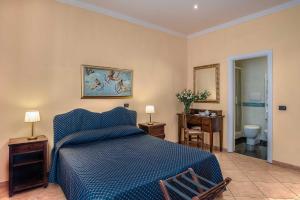 a bedroom with a blue bed and a bathroom at Hotel Caracciolo in Rome