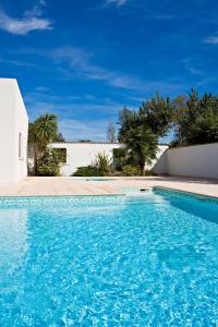 - une piscine d'eau bleue en face d'une maison dans l'établissement Vacancéole - Résidence Carré Marine, à Mandelieu-la-Napoule