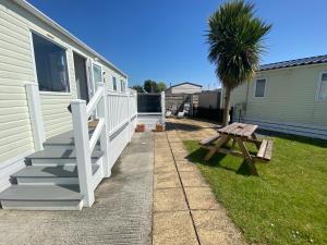 a porch of a house with a picnic table and a palm tree at 4 Sandringham, Patrington Haven, Hot Tub, Private garden & Parking in Patrington +1 photo
