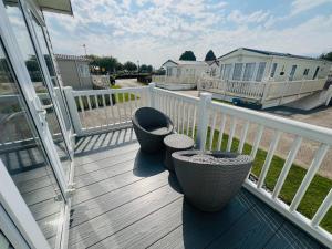 a porch with two chairs on a deck at 4 Sandringham, Patrington Haven, Hot Tub, Private garden & Parking in Patrington