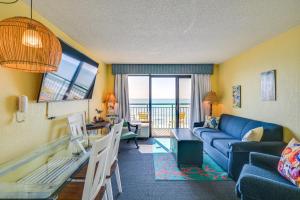 a living room with a blue couch and a table at Myrtle Beach Oceanfront Condo w/ Pool & Lazy River in Myrtle Beach