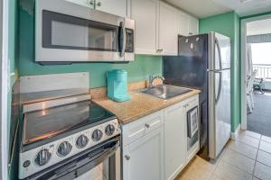 a kitchen with a stove and a sink and a microwave at Myrtle Beach Oceanfront Condo w/ Pool & Lazy River in Myrtle Beach