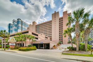 a building with palm trees in front of a street at Myrtle Beach Oceanfront Condo w/ Pool & Lazy River in Myrtle Beach