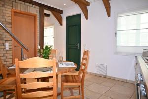 a dining room with a table and chairs and a green door at Gemütliches Fachwerkhaus in Werne an der Lippe