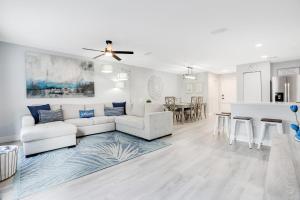 a living room with a white couch and a kitchen at Stylish Villa Near Disney & Universal in Kissimmee +30 photos
