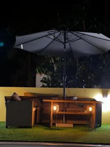a table with an umbrella next to a couch and a bench at SUNNY CARMELITO DELUXE in Mogán