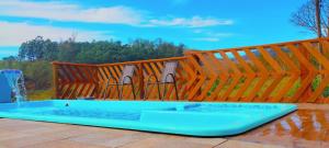 - une piscine avec 2 chaises à côté d'une clôture en bois dans l'établissement Chácara paraíso, à Socorro