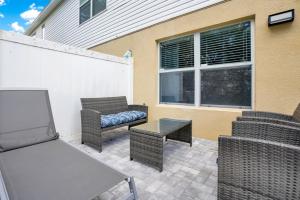 a patio with wicker chairs and a couch and a table at Stylish Villa Near Disney & Universal in Kissimmee