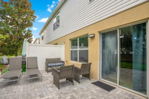 a patio with two chairs and a table and chairs at Stylish Villa Near Disney & Universal in Kissimmee