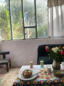 einen Tisch mit einem Teller Essen und einer Vase Blumen in der Unterkunft Ali's House in Marrakesch