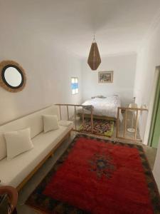 ein Wohnzimmer mit einer weißen Couch und einem roten Teppich in der Unterkunft Ali's House in Marrakesch
