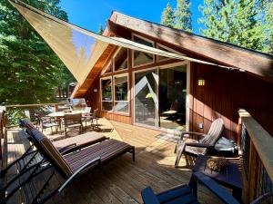 una casa con terraza con banco y sillas en Edelweiss Retreat- Close to Lake and Ski Resorts- Pet Friendly- Hot Tub, en Tahoe City