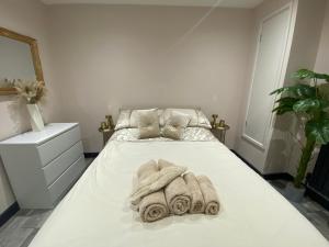 a white bedroom with a bed with towels on it at Rivendell spacious two bedroom 1st floor flat in Kent