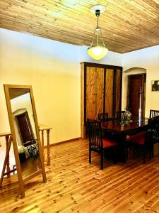 a dining room with a table and chairs and a mirror at Traditional old house in Dhërmi