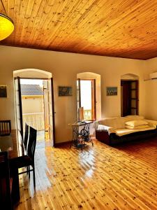 a bedroom with a bed and a wooden ceiling at Traditional old house in Dhërmi