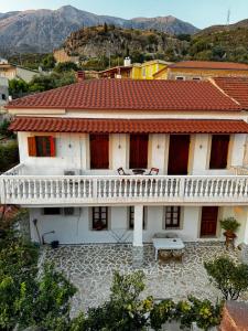 a white house with a table in front of it at Traditional old house in Dhërmi