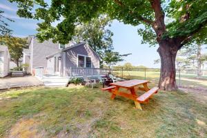a picnic table in front of a house with a tree at Osprey's Nest in West Hyannisport