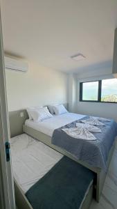 a bed in a room with a window at Mirante do Porto in Porto De Galinhas