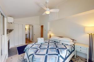 a white bedroom with a bed with two white chairs at Osprey's Nest in West Hyannisport