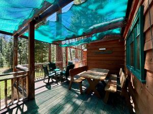 eine abgeschirmte Veranda mit einem Tisch und Stühlen in der Unterkunft Ward Creek Retreat - Cozy Old Tahoe Cabin w Short Drive to Ski Resorts Pet Friendly in Tahoe City