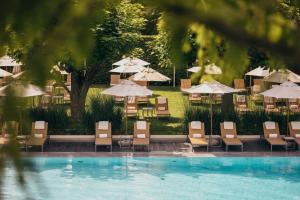 a group of chairs and umbrellas next to a pool at InterContinental Genève by IHG in Geneva