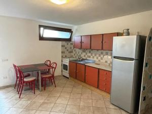 una cocina con una mesa y un refrigerador en villa Mirtilla, en Villasimius 14 fotos más