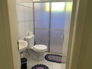 a white bathroom with a toilet and a sink at Espaço e conforto 1 in Guaíra +5 photos