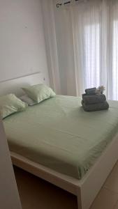 ein Schlafzimmer mit einem großen Bett mit grüner Bettwäsche und einem Fenster in der Unterkunft La Casa Rosita, Hacienda Riquelme Golf Resort Sucina in Murcia + 10 Fotos