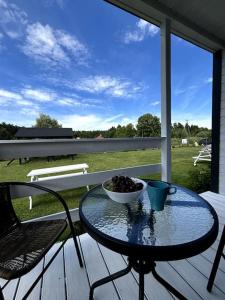 a glass table with a bowl of food on a porch at Domki Nadmorska fala Rusinowo in Rusinowo