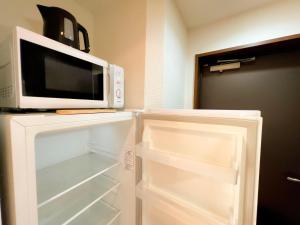 Elle comprend un réfrigérateur et un four micro-ondes. dans l'établissement Shinjuku NZO Apt, à Tokyo