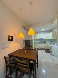 eine Küche mit einem Holztisch und zwei Lampen in der Unterkunft HaBiBi hOmE Klcc in Kuala Lumpur
