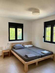 ウルツィニにあるB&K Villa Kručeの窓が2つある部屋にある大きなベッド