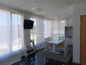 Un comedor con mesa y sillas y ventanas. en Mountain Relax Vlašić, en Vlašić