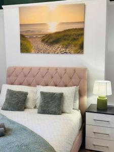 a bedroom with a bed with a painting on the wall at Blessed Princess House With Free Parking in Sunderland