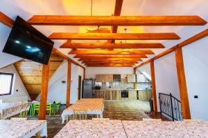 ラシュノフにあるCasa Diana Rasnovの木製の天井とテレビ付きのリビングルーム