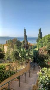 a walkway with trees and the ocean in the background at Vue de rêve sur lagune de mer in Bages