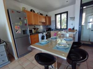 a kitchen with a table with chairs and a refrigerator at Vue de rêve sur lagune de mer in Bages