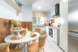 a kitchen with a white table and chairs at Blue City apartments in Trenčín