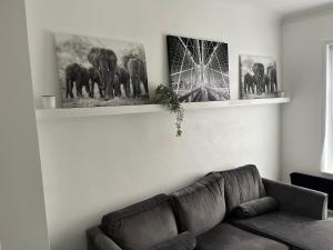 a living room with a couch and pictures on the wall at 3 Bed House - Sleeps 5 - Garden - Parking - Wifi in Dartford +2 photos
