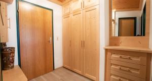ケーニヒスライテンにあるAppartement Dettlbauer Top 16の木製の戸棚と鏡が付いたクローゼットのある部屋