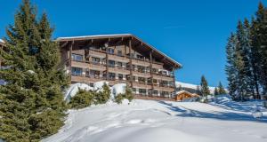 ケーニヒスライテンにあるAppartement Dettlbauer Top 16の前に雪が積もった大きな建物