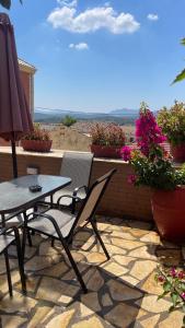 a patio with a table and chairs and flowers at Lori House in Corfu. Feel like your home in Skriperón