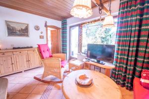 un salon avec une table et une télévision dans l'établissement Höchstädter Hütte, à Königsleiten