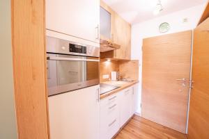 een keuken met witte kasten en een spoelbak bij Kreidl Top 37 in Königsleiten +3 foto's