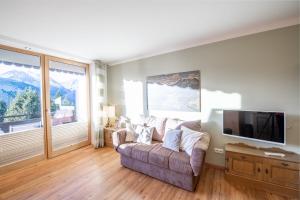 een woonkamer met een bank en een flatscreen-tv bij Kreidl Top 37 in Königsleiten